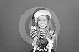 Its Xmas season. Happy child hold xmas tree ball. Little girl smile in xmas costume red background. Merry xmas to you