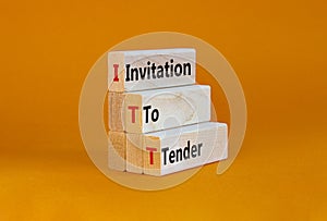 ITT invitation to tender symbol. Concept words ITT invitation to tender on blocks on a beautiful orange table, orange background.