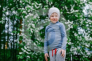 Ittle boy on a background of flowering cherry