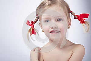 ittle Caucasian Girl Posing With Long Pigtails Against White Background