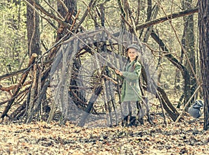 Ittle cute girl builds a hut in the woods