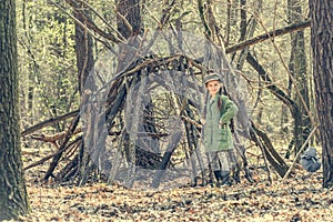 Ittle cute girl builds a hut in the woods