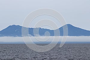 Iturup Island volcanoes on foggy horizon. The Sea of Okhotsk, Kuril Islands, Russia, claimed by Japan.