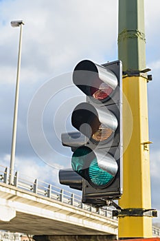 Ð¡ity traffic with traffic lights, in the foreground a traffic light with a green light