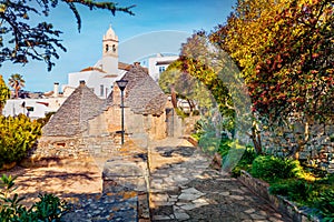 Ityscape of Alberobello town with Edicola Votiva statua Madonnina church, Apulia region, Italy