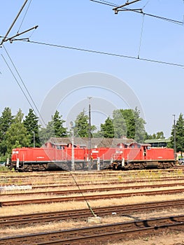 View of red locomotive and multiple train tracks from platform at Itzehoe train station