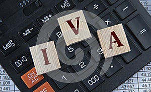 IVA - acronym on wooden cubes on the background of a calculator