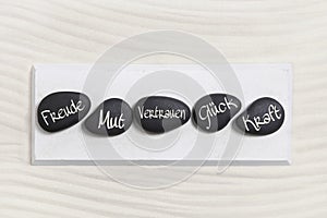 Ive black stones with german text for happiness, courage, trust,