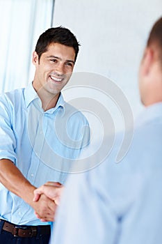Ive got the best handshake in Hollywood. Shot of a handsome young man shaking hands with a colleague in the office.