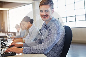 Ive got a great team behind me. Cropped portrait of a young businessman working in the office with his colleagues.