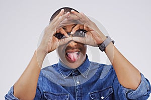 Ive got my party goggles on. Studio shot of a young man making a funny face against a gray background.
