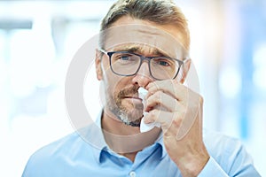 Ive got the sniffles. Cropped portrait of a handsome mature businessman blowing his nose.