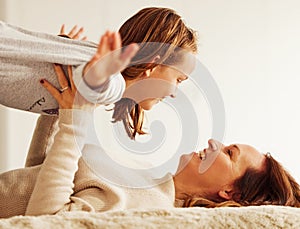 Ive got you, dont worry. an attractive young mother lying on the bed at home and bonding with her daughter.