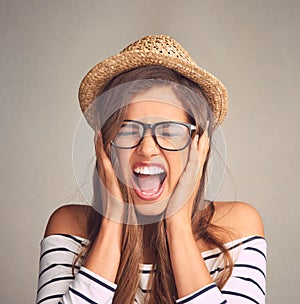 Ive had enough. Studio shot of an attractive young woman screaming against a gray background.