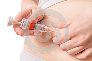 IVF and artificial insemination concept. Woman is injecting hormones to belly with syringe photo