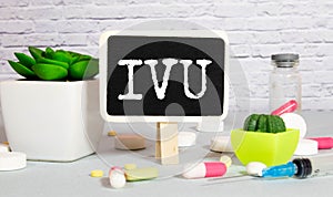 IVU. text on white paper, gray background, near pills and stethoscope in blue