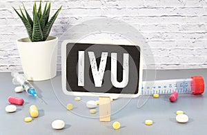 IVU. text on white paper, gray background, near pills and stethoscope in blue photo