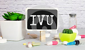 IVU. text on white paper, gray background, near pills and stethoscope in blue photo