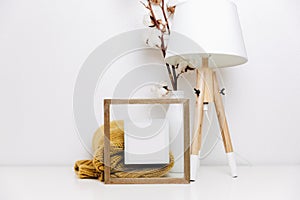 IWooden frame with place for text. Cotton branches, skandi lamp and sweater.