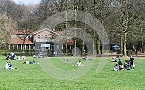 Ixelles, Brussels Belgium - Mixed group of people walking and resting at the green lawns of the Bois de La Cambre city park