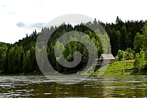 Izba on the Siberian mountain taiga and river Mana photo