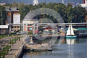 Izhevsk, Republic of Udmurtia, Russia - 08.16.2022. Chapel of Catherine the Great Martyr, sailboat and industrial buildings of the