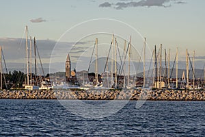 Izola / SLOVENIA - June 25, 2018: Marina with many boats against sunset. Picturesque summer scenery with Izola church tower