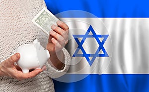 Izraeli woman with money bank on the background of Izrael flag. Dotations, pension fund, poverty, wealth, retirement concept
