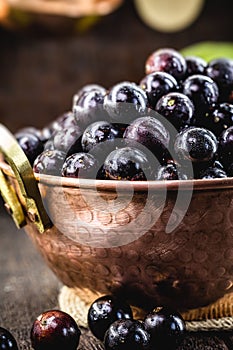 Jabuticaba. Brazilian and South American tropical fruits, in a copper pot on a rustic table photo