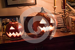 Jack-o`-lantern carved pumpkins on a furniture dribbling.