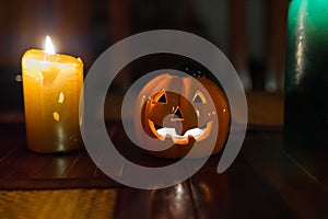 Jack-o`-lantern ceramic candle on a wooden table