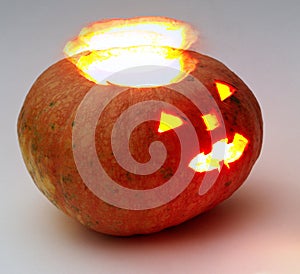 Jack o lantern. halo-like glow separates from entrails. Orange round pumpkin with lantern inside and glows. Close-up