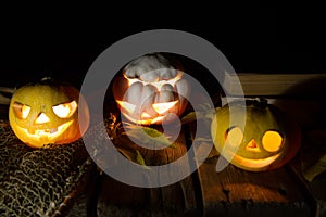 Jack O`Lantern. A pumpkin with burning eyes. A pumpkin for Halloween on an old wooden table against the background of old books.