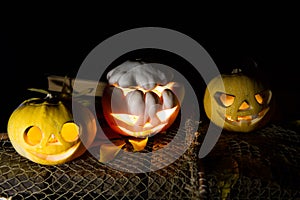 Jack O`Lantern. A pumpkin with burning eyes. A pumpkin for Halloween on an old wooden table against the background of old books.