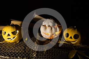 Jack O`Lantern. A pumpkin with burning eyes. A pumpkin for Halloween on an old wooden table against the background of old books.