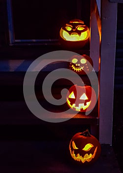 Jack o` lanterns, glowing on the front steps of a house