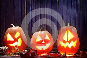 Jack o lanterns Halloween pumpkin face on wooden background