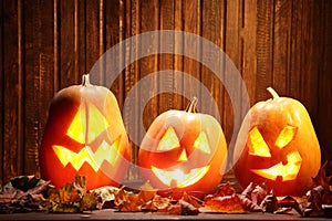 Jack o lanterns Halloween pumpkin face on wooden background and