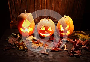 Jack o lanterns Halloween pumpkin face on wooden background