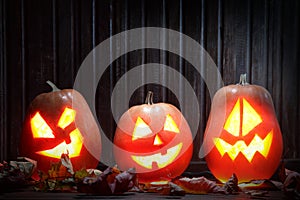 Jack o lanterns Halloween pumpkin face on wooden background