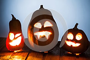 Jack o lanterns Halloween pumpkin face on wooden background