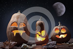 Jack o lanterns Halloween pumpkin face on wooden background