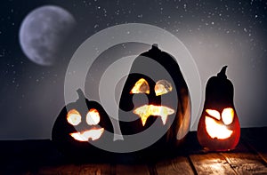 Jack o lanterns Halloween pumpkin face on wooden background