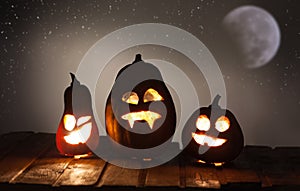 Jack o lanterns Halloween pumpkin face on wooden background