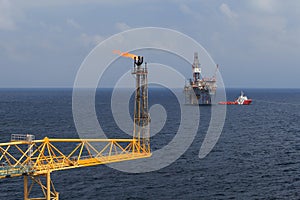 Jack up drilling rig, flare boom, and crew boat