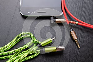 Jack and usb cable for smartphone. Telephone and accessories on the table