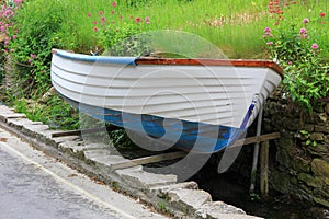 Jacked up rowing boat beside the street