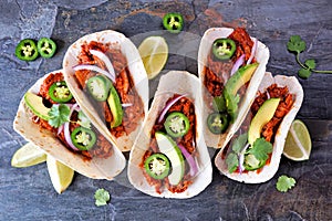 Jackfruit vegan tacos overhead view on a dark stone background