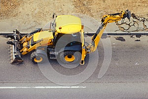 Jackhammer excavator smash old asphalt on city road, top view