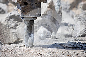 Jackhammer hammering concrete for hole and making dust